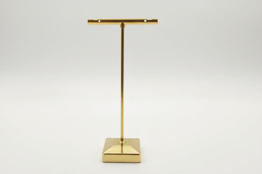 Soporte metálico dorado tipo “T”.